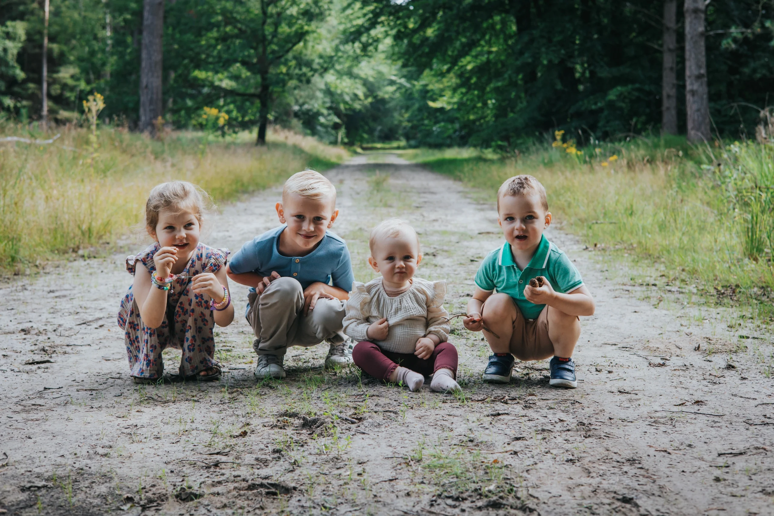 Four children sitting on forest path